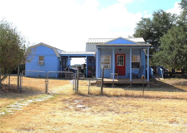 view of front facade featuring a gate, covered porch, metal roof, and fence private yard