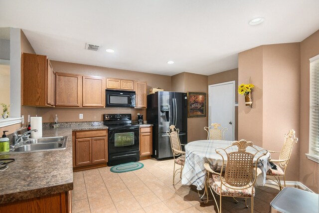 kitchen featuring light tile patterned floors, sink, and black appliances