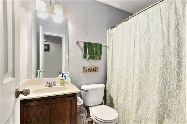 bathroom with toilet, vanity, and curtained shower