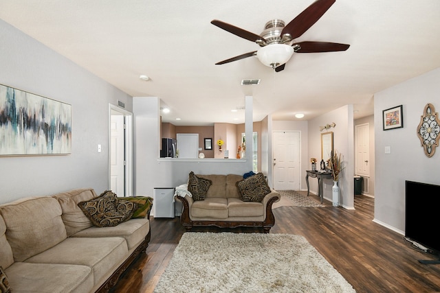 living room featuring ceiling fan and dark hardwood / wood-style flooring