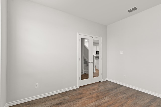 spare room featuring dark hardwood / wood-style floors and french doors