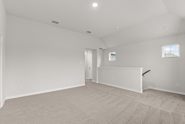 carpeted empty room featuring a healthy amount of sunlight and vaulted ceiling