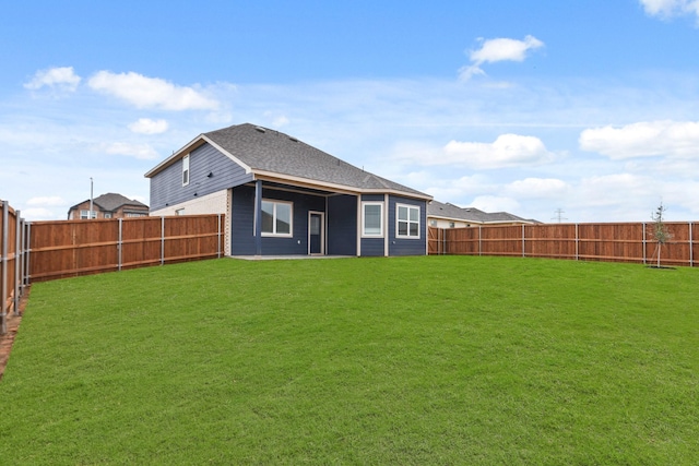 rear view of property featuring a lawn