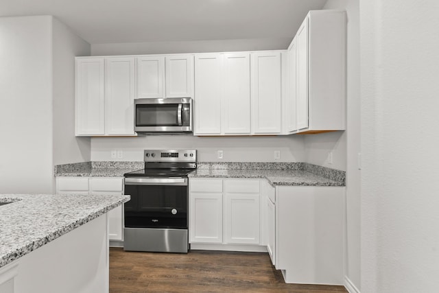 kitchen featuring light stone countertops, white cabinetry, appliances with stainless steel finishes, and dark hardwood / wood-style floors