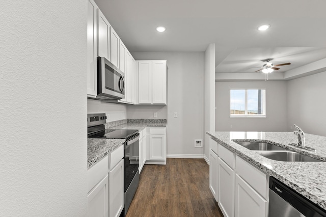 kitchen with white cabinetry, appliances with stainless steel finishes, sink, and light stone counters