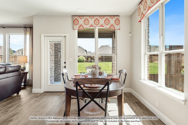 dining area featuring plenty of natural light and light hardwood / wood-style flooring