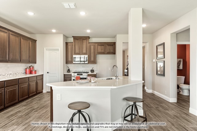 kitchen with sink, a breakfast bar area, backsplash, and stainless steel appliances