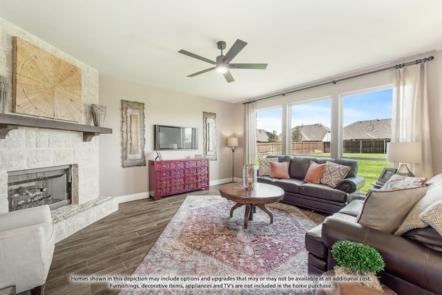 living room with ceiling fan, dark hardwood / wood-style floors, and a stone fireplace