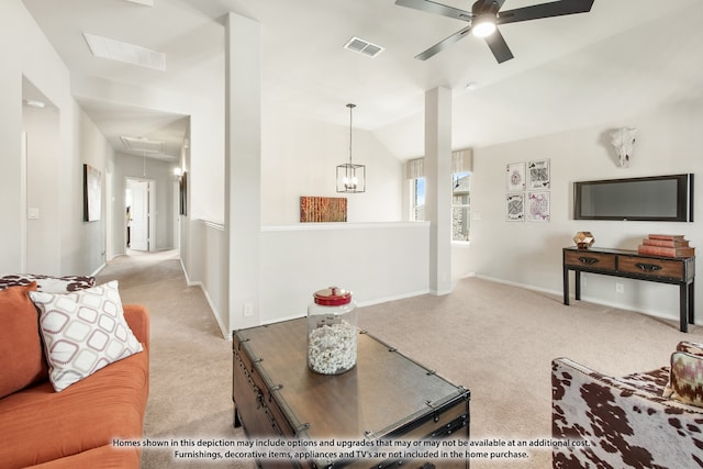 carpeted living room with ceiling fan with notable chandelier and vaulted ceiling