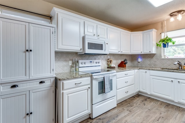 kitchen featuring sink, white appliances, and white cabinets