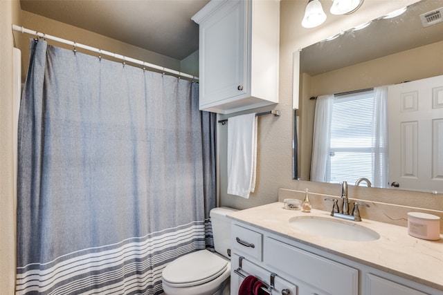 bathroom with curtained shower, toilet, and vanity