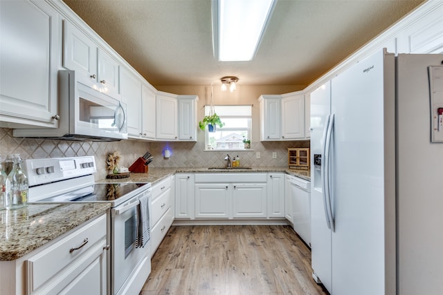 kitchen featuring light wood-type flooring, white appliances, light stone countertops, white cabinetry, and sink