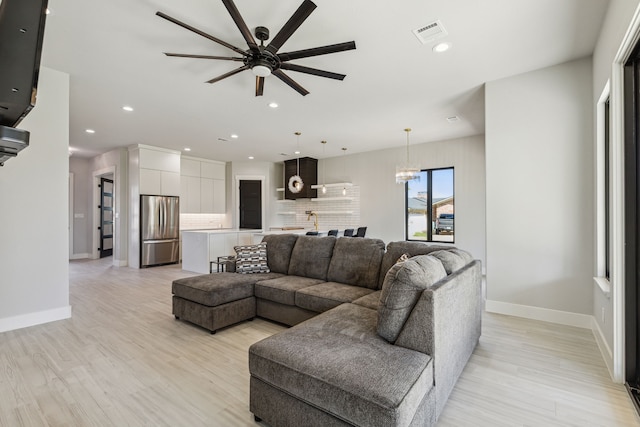 living room featuring light wood-type flooring and ceiling fan