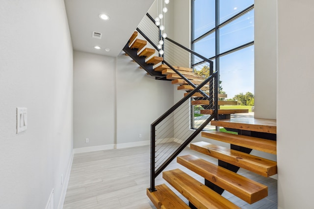 stairway with a high ceiling and hardwood / wood-style floors