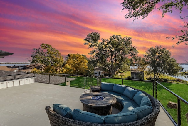 patio terrace at dusk with a lawn and an outdoor fire pit