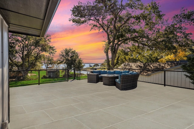 patio terrace at dusk featuring a balcony and an outdoor living space