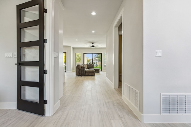 hallway with light hardwood / wood-style floors