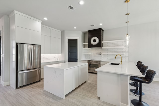 kitchen featuring appliances with stainless steel finishes, decorative light fixtures, tasteful backsplash, sink, and kitchen peninsula