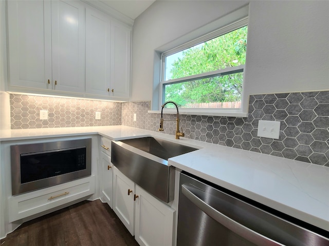 kitchen with dark hardwood / wood-style floors, sink, white cabinets, backsplash, and stainless steel dishwasher