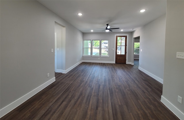 empty room with ceiling fan and dark hardwood / wood-style flooring