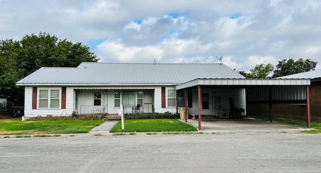 view of front of home with a carport, a front yard, and covered porch