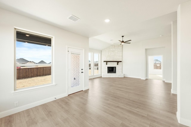 unfurnished living room with a fireplace, light hardwood / wood-style floors, vaulted ceiling, and ceiling fan