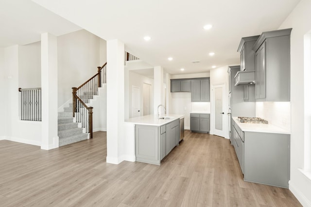 kitchen featuring gray cabinets, sink, light wood-type flooring, and dishwasher