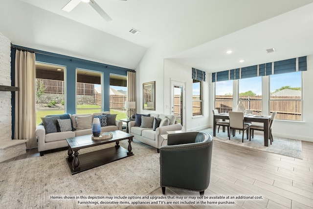 living room featuring ceiling fan, lofted ceiling, light hardwood / wood-style floors, and a healthy amount of sunlight