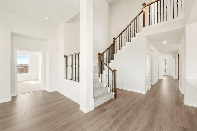 living area featuring a wealth of natural light, vaulted ceiling, and light carpet