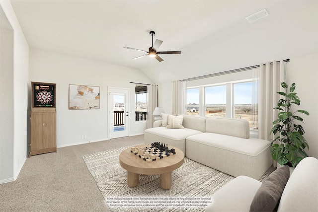 living room with a wealth of natural light, ceiling fan, light colored carpet, and lofted ceiling