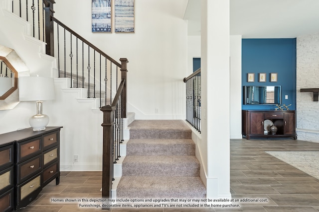 stairway with hardwood / wood-style floors and a towering ceiling