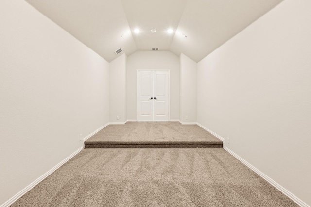 empty room featuring carpet and lofted ceiling