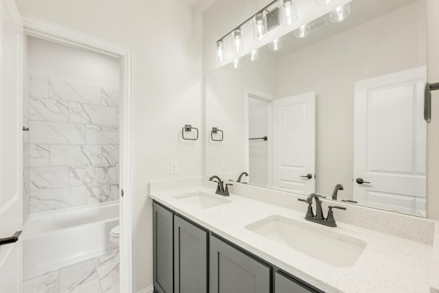 full bathroom featuring toilet, vanity, and tiled shower / bath