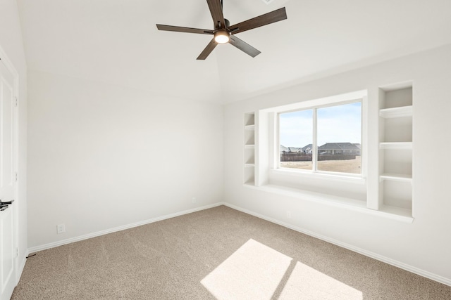 spare room with lofted ceiling, ceiling fan, built in features, and carpet floors