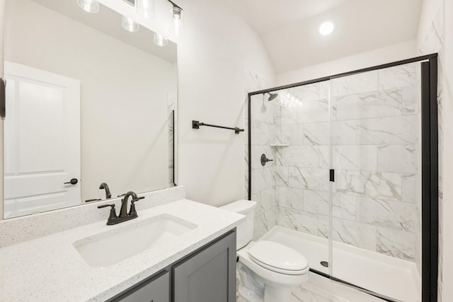 bathroom with vanity, toilet, and a shower with door