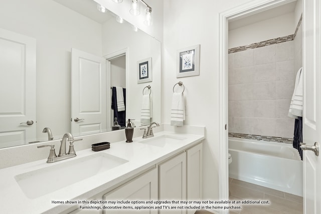 full bathroom with tile patterned floors, double sink vanity, tiled shower / bath combo, and toilet