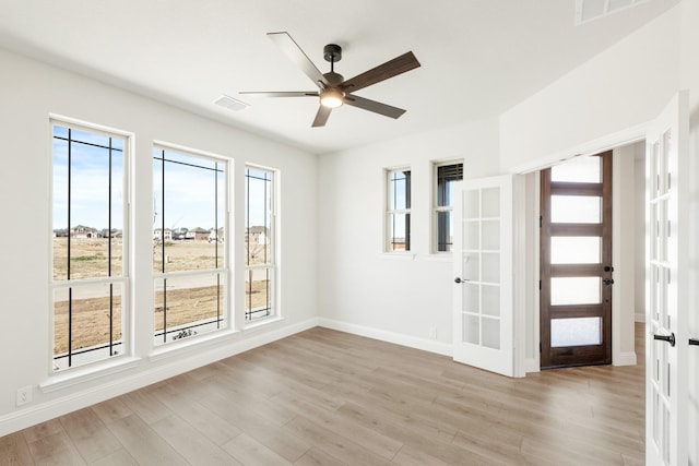 unfurnished room featuring ceiling fan, light wood-type flooring, and french doors