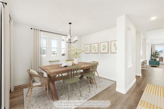 dining area with light hardwood / wood-style floors, a chandelier, and a healthy amount of sunlight