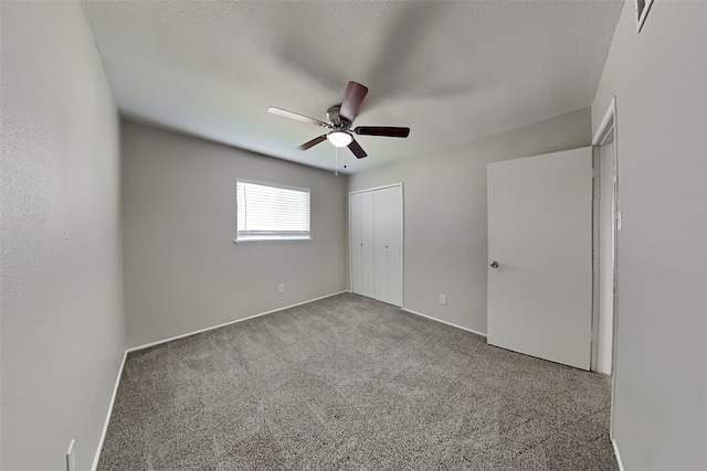 unfurnished bedroom with a closet, carpet flooring, ceiling fan, and a textured ceiling