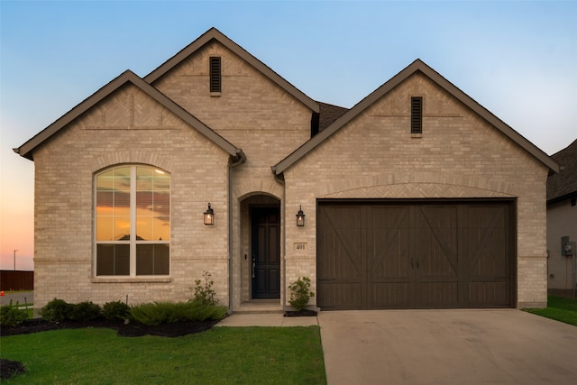 view of front of house with a yard and a garage