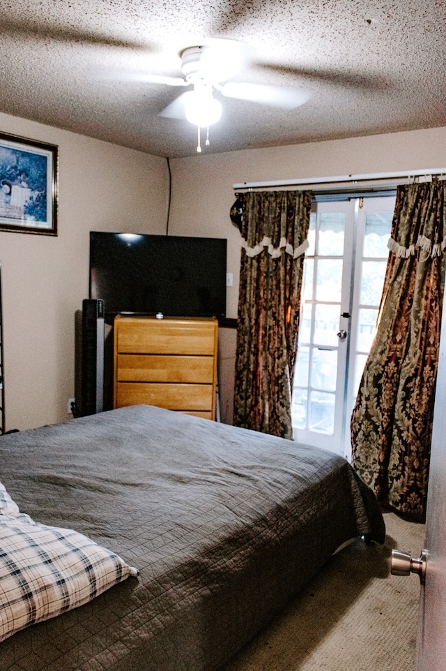 carpeted bedroom with a textured ceiling, ceiling fan, and french doors