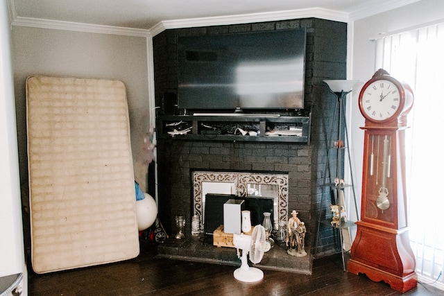 living room with crown molding, a brick fireplace, and hardwood / wood-style floors