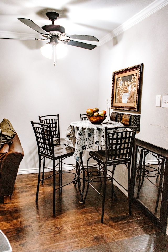 dining room with ornamental molding, dark wood-type flooring, and ceiling fan