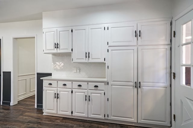 kitchen featuring dark hardwood / wood-style floors, decorative backsplash, and white cabinetry