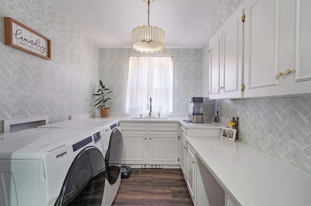 laundry room with cabinets, independent washer and dryer, a chandelier, sink, and dark wood-type flooring