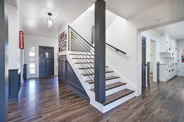 staircase with crown molding and hardwood / wood-style floors