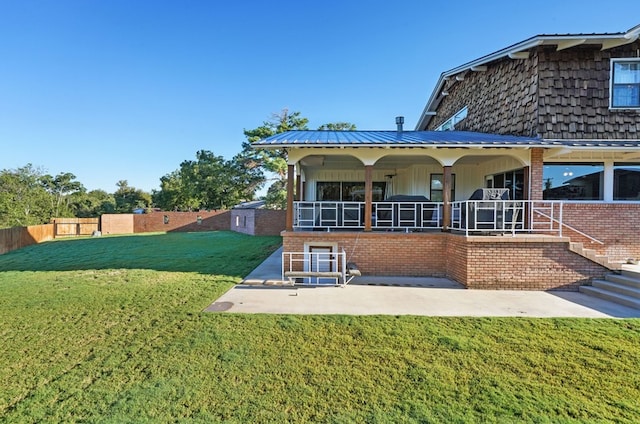 back of house featuring a patio area and a lawn