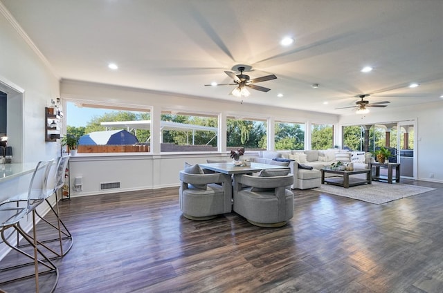 living room featuring dark wood-type flooring, ceiling fan, and crown molding