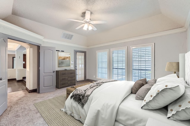 bedroom featuring ceiling fan, a tray ceiling, ornamental molding, a textured ceiling, and light colored carpet