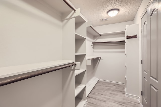 spacious closet with light hardwood / wood-style flooring